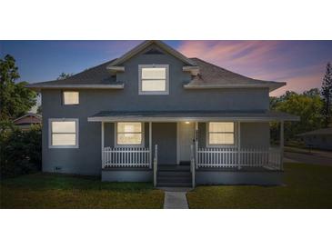 Charming two-story home with a welcoming front porch and manicured lawn, perfect for relaxation at 1048 W Lime St, Lakeland, FL 33815