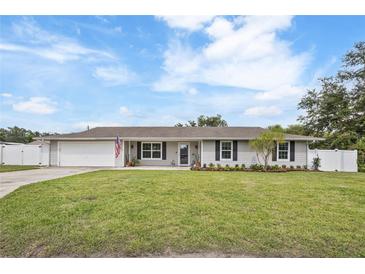 Charming single-story home with a manicured lawn, fresh flowers, and a classic American flag at 5324 Messina, Lakeland, FL 33813