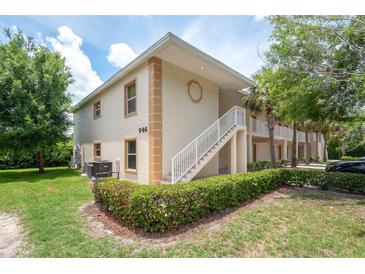 Inviting condo building with manicured landscaping and a white stairwell, offering convenient access to upper-level units at 946 15Th St # 202, Daytona Beach, FL 32117