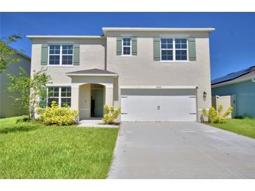 Charming two-story home featuring a well-manicured lawn and light green shutters with complementary front door at 2005 Carnostie Rd, Winter Haven, FL 33884