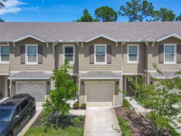 View of townhomes featuring attached garages, neutral colors, and well-maintained landscaping at 67 Bella Oaks Dr, Port Orange, FL 32129