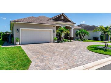 Charming single-Gathering home featuring a brick paved driveway, two car garage, and tropical landscaping at 3249 Pearly Dr, Lakeland, FL 33812