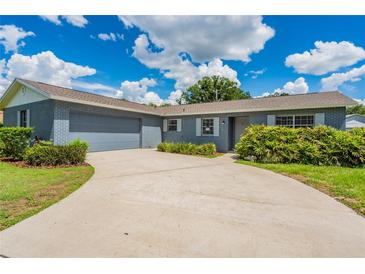 Charming single-story home featuring a gray brick exterior, attached garage, and well-maintained landscaping at 1327 Glenview Ln, Lakeland, FL 33813