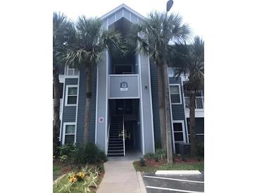 Exterior view of a multi-story condo building with palm trees and visible unit access at 709 Secret Harbor Ln # 313, Lake Mary, FL 32746