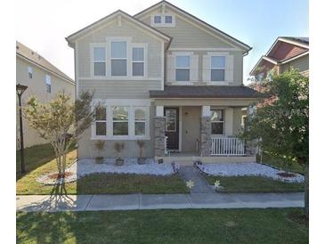 Charming two-story home featuring a well-maintained lawn and inviting front porch at 1704 Felicity Ln, Kissimmee, FL 34744