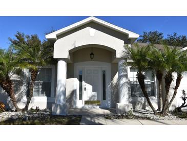 House exterior featuring a white door, arched entryway, and palm trees at 1562 Pendleton St, Deltona, FL 32725