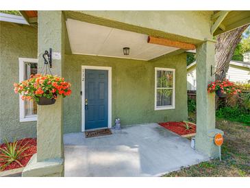 Inviting front porch with hanging flower baskets and a charming door at 112 S Chandler Ave, Deland, FL 32724