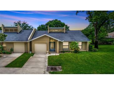 Charming single-story townhome featuring an attached garage, front lawn, and covered entryway at 34 Fairway Dr # 1, Debary, FL 32713