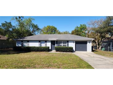 Charming single-story home with gray siding, manicured hedges, and a well-maintained front yard at 250 Hickory Ave, Orange City, FL 32763