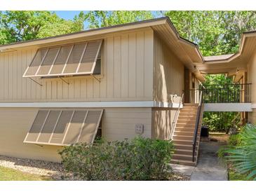 Inviting two-story condo with neutral siding, louvered windows and a private entrance via stairway at 140 Orchid Woods Ct # 11A, Deltona, FL 32725