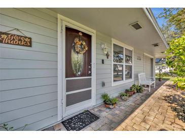 Inviting front porch with brick pavers, potted plants, and a charming door at 4430 Doris Dr, New Smyrna Beach, FL 32169