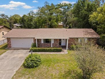 Charming single-story brick home with a well-manicured front yard and an attached garage at 1639 Templewood Ave, Deltona, FL 32725