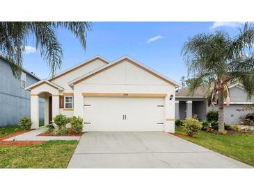 Charming single-story home with a two-car garage, lush landscaping, and a well-manicured lawn at 2924 Taton Trce, New Smyrna Beach, FL 32168