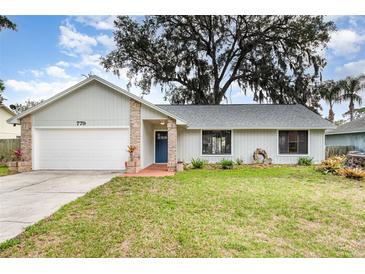 Charming single-story home featuring a well-manicured lawn and an attached two-car garage at 779 Victoria E Cir, Ormond Beach, FL 32174