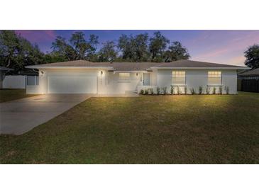 Charming single-story home with a well-manicured lawn, garage, and inviting front entrance at 7360 Canal Dr, Sanford, FL 32771