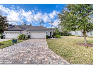 Attractive home exterior with a paved driveway and landscaped lawn at 751 Aldenham Ln, Ormond Beach, FL 32174