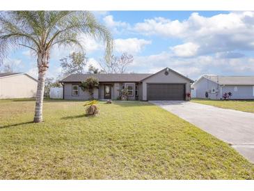 Charming one-story house with gray exterior, landscaping, and a two-car garage at 3164 Chamberlain St, Deltona, FL 32738