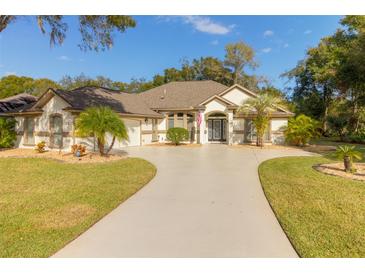 Single-story house with a circular driveway and landscaped lawn at 3605 Galway Ln, Ormond Beach, FL 32174