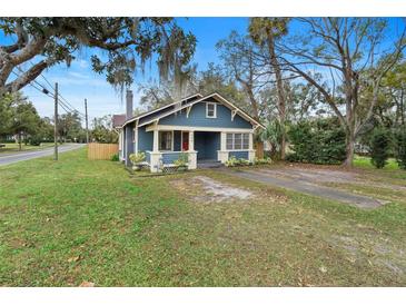 Charming blue bungalow with front porch and lush landscaping at 448 E Church St, Deland, FL 32724