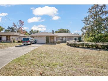 Brick ranch house with carport, landscaping, and large yard at 783 S Atmore Cir, Deltona, FL 32725