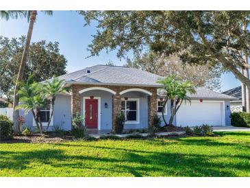 Single-story home with stone accents, red door, and landscaped lawn at 12 Peruvian Ln, Ormond Beach, FL 32174