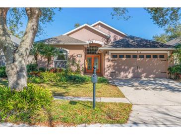 Charming single-story home with manicured lawn, an orange front door, and attached two-car garage at 1278 Chessington Cir, Lake Mary, FL 32746