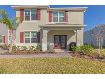 Two-story house with red shutters, double doors, and a landscaped yard at 3033 Meleto Blvd, New Smyrna Beach, FL 32168