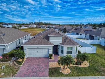 Aerial view of a single-Gathering home with a brick driveway and landscaped yard at 962 Compass Landing Dr, Orange City, FL 32763