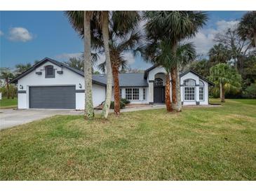 Beautiful single-story home with gray roof and attached garage at 130 Old Sunbeam Dr, South Daytona, FL 32119
