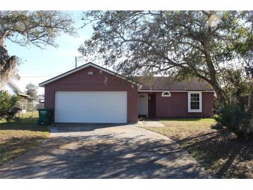 Cute ranch home with a white garage door and mature landscaping at 3019 N Covington Dr, Deltona, FL 32738