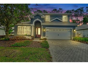 Charming two-story home with a brick driveway, two-car garage, landscaped yard and covered front entry at 204 Wellington Woods Ave, Deland, FL 32724