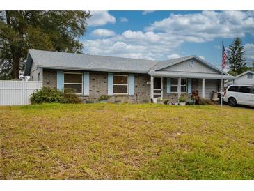 Ranch-style home with brick facade, spacious yard, and American flag at 262 Valencia Rd, Debary, FL 32713