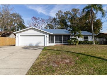 House exterior showcasing a white single-story home with a two-car garage and a well-maintained lawn at 2709 Queen Palm Dr, Edgewater, FL 32141