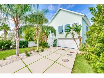 Light teal house with white garage and lush landscaping at 3110 John Anderson Dr, Ormond Beach, FL 32176