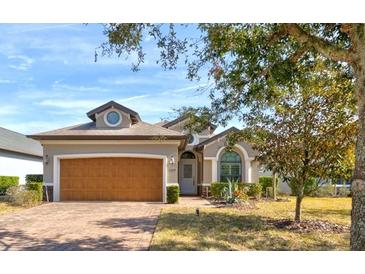 Charming single-story home featuring a brick driveway, manicured lawn, and a symmetrical façade at 3169 Connemara Dr, Ormond Beach, FL 32174