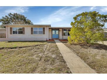 Charming single-story home featuring a blue front door, light-colored brick, and well-maintained landscaping at 641 Hartley Ave, Deltona, FL 32725