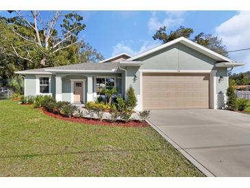 Newly constructed home with attached garage and well-manicured lawn at 731 E Cox St, Deland, FL 32724