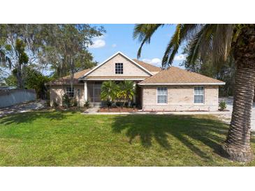 Charming single-story brick home with a well-manicured lawn and mature landscaping at 2424 India Blvd, Deltona, FL 32738