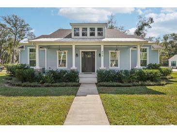 Charming single-story home with a welcoming front porch and well-maintained landscaping at 475 W Main St, Lake Helen, FL 32744