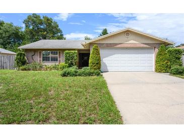 Brick ranch house with a two-car garage and well-maintained lawn at 1016 Martex Dr, Apopka, FL 32703