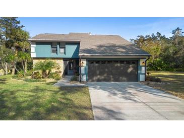 Beautiful two-story home featuring a two-car garage, stone accents, and mature landscaping at 149 Sheryl Dr, Deltona, FL 32738