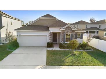 Single-story home with a two-car garage and well-manicured lawn at 164 E Fiesta Key Loop, Deland, FL 32720