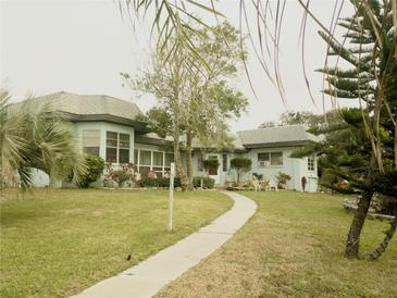 Light blue single story home with a walkway and lush landscaping at 2201 S Peninsula Dr, Daytona Beach, FL 32118