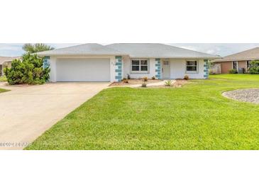 Charming single-story home featuring a lush green lawn, clean driveway, and neat landscaping at 24 Sea Gull Dr, Ormond Beach, FL 32176