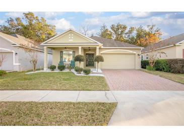 House exterior featuring a two-car garage and well-manicured lawn at 242 W Fiesta Key Loop, Deland, FL 32720
