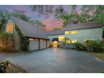 Inviting two-story home featuring an attached two-car garage, lush landscaping, and a well-maintained driveway at 120 Beach St, Ponce Inlet, FL 32127
