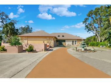 Charming single-story home featuring stone accents and a lush, landscaped front yard with a water feature at 1924 Seclusion Dr, Port Orange, FL 32128