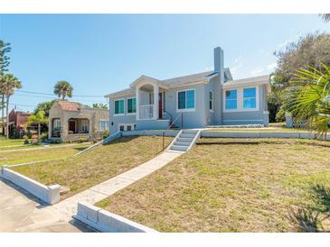 Charming blue two-story home with a landscaped yard and inviting front porch at 408 Wisteria Rd, Daytona Beach, FL 32118