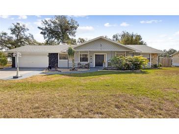 Charming single-story home with a well-manicured lawn and inviting front porch at 480 Columbus Ave, Orange City, FL 32763