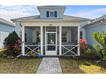 Charming home featuring a spacious screened-in front porch, stone walkway, and well-maintained landscaping at 562 Landshark Blvd, Daytona Beach, FL 32124